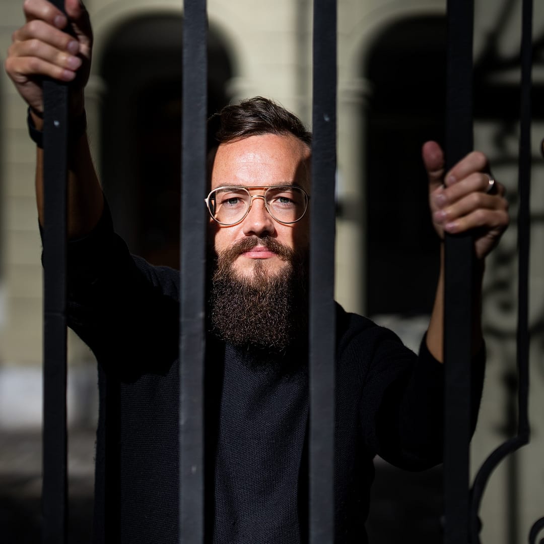 Simon Schütz hinter einem Zaun in Bern.